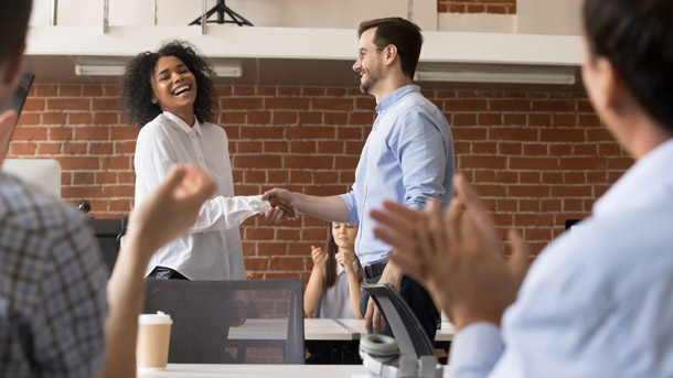 Man and woman shake hands for kick off of employer program